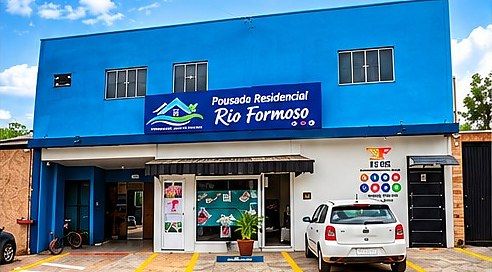 Fachada azul da Pousada Residencial Rio Formoso, com estacionamento na frente